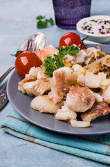 Slices of fried fish with vegetables