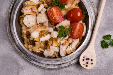 Slices of fried fish with vegetables
