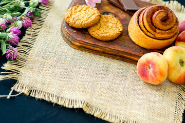 Obraz na płótnie Canvas Homemade cinnamon buns in glaze on a dark plate with berries