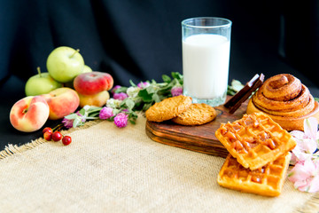 Homemade cinnamon buns in glaze on a dark plate with berries