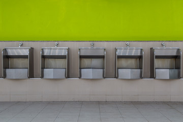 Row of stainless steel urinals in public toilets