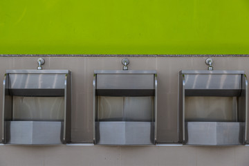 Row of stainless steel urinals in public toilets