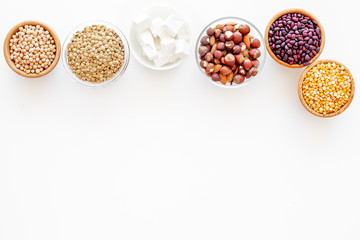 Obraz na płótnie Canvas Vegan protein source. Legumes, nuts, cheese. Raw beans, chickpeas, lentil, almond, hazelnut on white background top view copy space