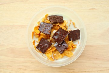 Cornflakes with chocolate and milk on brown wood background,Top view.