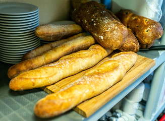 Different kinds of bread rolls on black chalkboard from above. Kitchen or bakery poster design