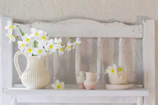 daffodils in jug on white background