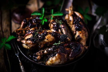 Quail with blackberry sauce.darck rustic photo