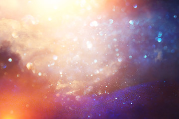 glitter vintage lights background. black, silver, purple and gold. de-focused.