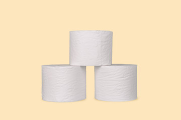 A stack of toilet paper rolls on light yellow color background.
