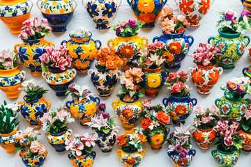 Fototapeta na wymiar Facade of a traditional house with decorative ceramic plates and pots of colorful flowers in the historic Albaicin neighbourhood.