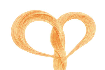 Long blond hair in shape of heart on white background. Hair care concept 