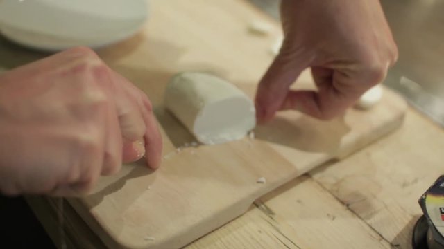 Cutting Round Goat Chese With A String