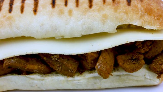 Spicy meat and cheese panini on close up rotating