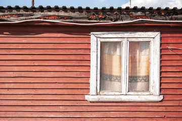 The wall of an old wooden house with a window