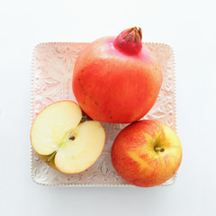 Rosh hashanah (jewish New Year holiday) concept. Pomegranate and apple raditional symbols. Flat lay.