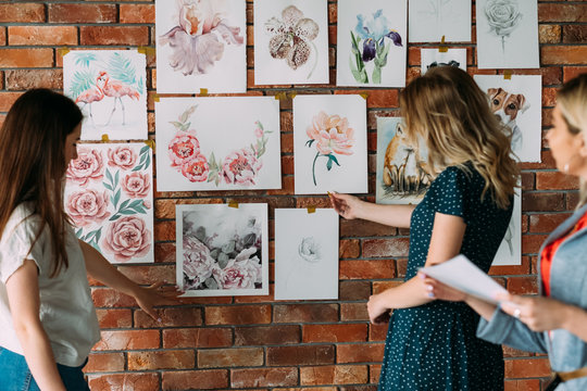 painting courses artwork. creative workshop decor. painting hobby and leisure concept. beautiful watercolor pictures of flowers and animals on the wall. students looking at drawings