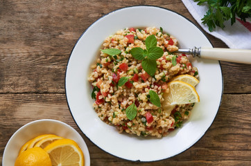 Salad with bulgur, tomatoes, cucumbers and fresh herbs