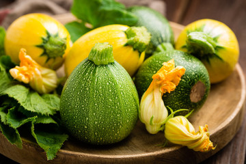 Zucchini with leaves and flowers on dark wooden rustic background