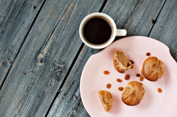 Cup of coffee, cakes and branch of a lilac on a gray wooden background