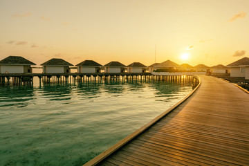 Tropical Water villas on Maldives island in sunrise time, holiday vacation background concept
