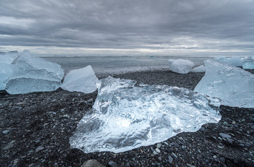 Icebergs washed onto a black sand beach at Jokulsarlon Glacier in Iceland on a beach known as Diamond Beach.