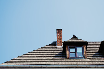 Roof of historic building with window and chimney