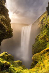 The fairytale like view of Skogafoss waterfall on a summer's day at sunset.