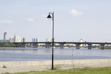 Fototapeta na wymiar Street lamppost under the blue sky overlooking the river
