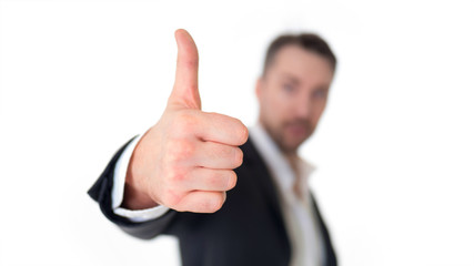 Smiling young business man thumbs up, isolated on white. Focus on the hand