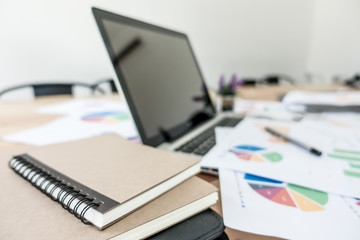 Business office table with paper peporting and laptop. Selective focus.