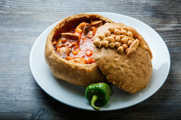 closeup fish soup in original homemade brown bread bowl