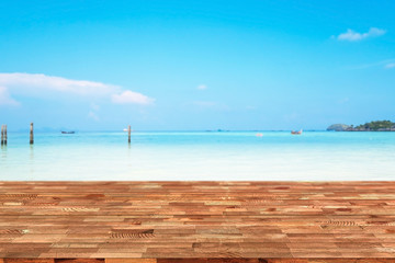 Perspective wooden table on top over blur sea in sunny day background. Beautiful sea and clouds in Thailand on summer, can be used mock up for montage products display or design layout.