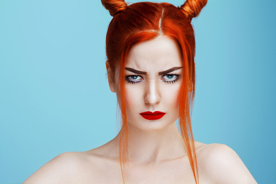 Beautiful naked caucasian girl with red hair and red lips frowns directly into the camera, photo of beauty wicked woman isolated with contrast toning. Hairstyle, skincare and cosmetics concept