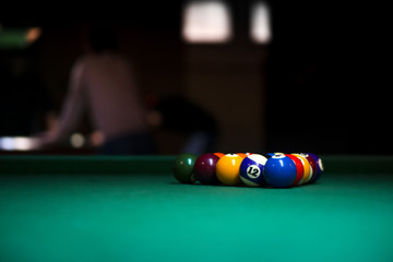 Sport billiard balls on green billiard table in pub. On going billiard game. Competitive players...