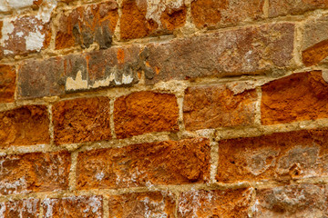 Photo of an ancient wall of red clay brick with a calcareous solution during the restoration. Restoration of the brick wall of the 1600s. Old brick masonry, shot at an angle close-up.