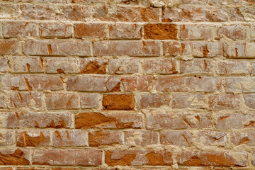 Photo of an ancient wall of red clay brick with a calcareous solution during the restoration. Restoration of plaster and whitewashing of the brick wall of the 1600s. Restoration of an old brick wall.