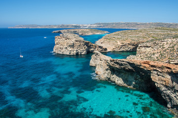 Fototapeta premium Comino, Malta - Comino island of the Maltese archipelago between the islands of Malta and Gozo in the Mediterranean Sea. Bright blue sea with some rocky islets in it. 