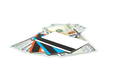 Dollar bills with credit cards on white.