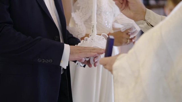 Priest praying in church at wedding ceremony and put on rings for newlyweds bride and groom
