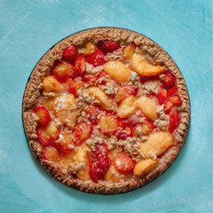 Homemade plum cake (pie) with crumble on turquoise background. Summer fruit crumble pastry.