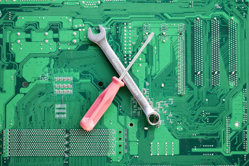 Green circuit board with wrench screwdriver. Template for text or icons. Repair engineering fix electronics motherboard background.