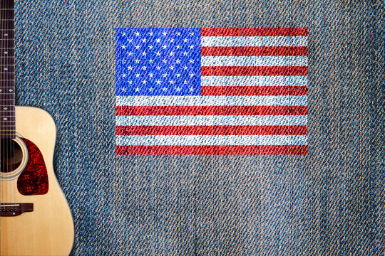 Acoustic guitar and American flag on a background of denim