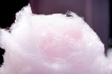 Selling cotton candy. Picking and holding pink cotton candy at a local state fair. Concept of unhealthy eating, too much sugar. Diabetes.  
