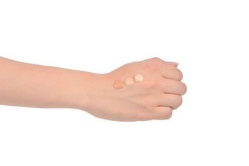 Fair, medium, dark swatches  of foundation on the hand isolated on white.