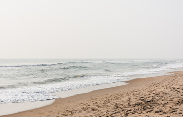 Fototapeta na wymiar Foamy water on calm beach - Foamy water at morning time on a tropical beach.