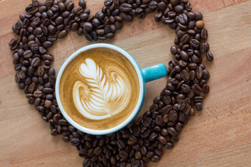 cup of coffee and beans on wooden background