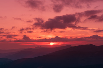 Amazing mountain landscape with colorful vivid sunset on the bright sky, natural outdoor travel background