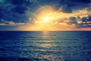 Beautiful bright colorful stunning sea sunset, rays of the sun in the clouds dramatic sunset over the ocean