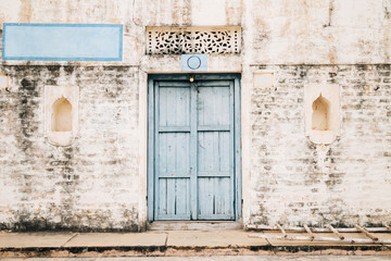 Fototapeta na wymiar Vintage style brick wall and sky blue wooden door, Old Indian house