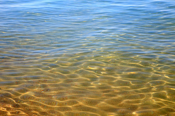 Blue clear water. Sea, lake, sun, beach, vacation Background for inserting images and text. Tourism, travel.